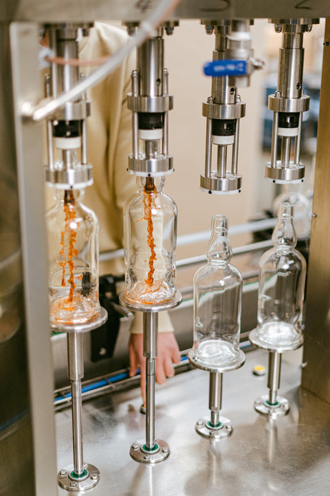 Ferg and Harris bottles being filled with whisky using a semi-automatic filler