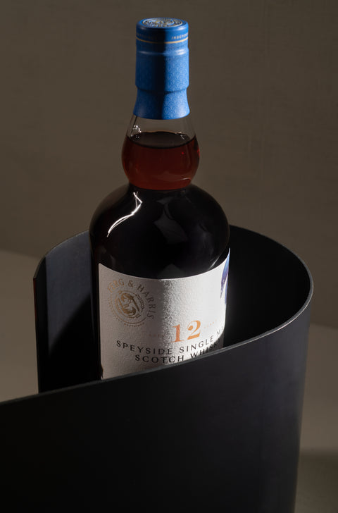 A bottle of a Ferg and Harris 12-year-old Speyside Single Malt hooded by a black ceramic spiral shape