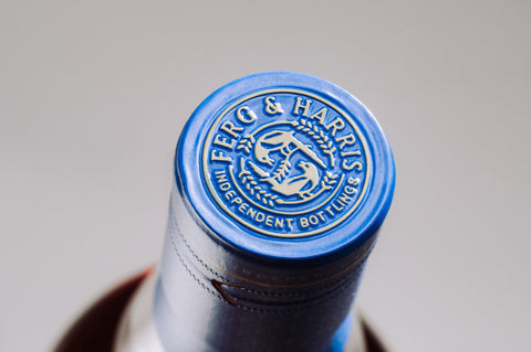 A top of Ferg and Harris bottle zoomed into the blue tin capsule with embossed Ferg and Harris roundel on it